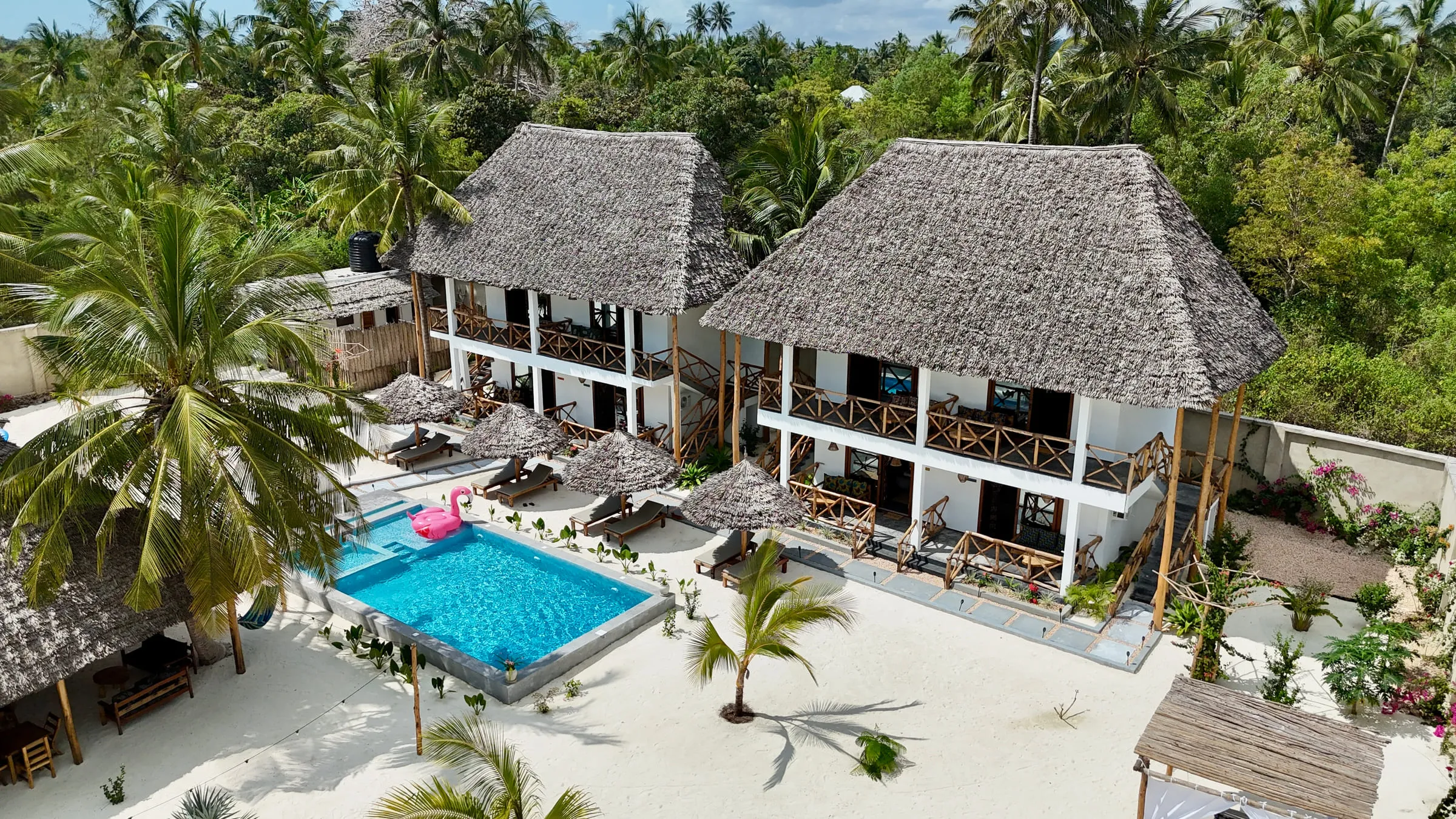 Aerial view looking down on the villas, the swimming pool and the palm garden