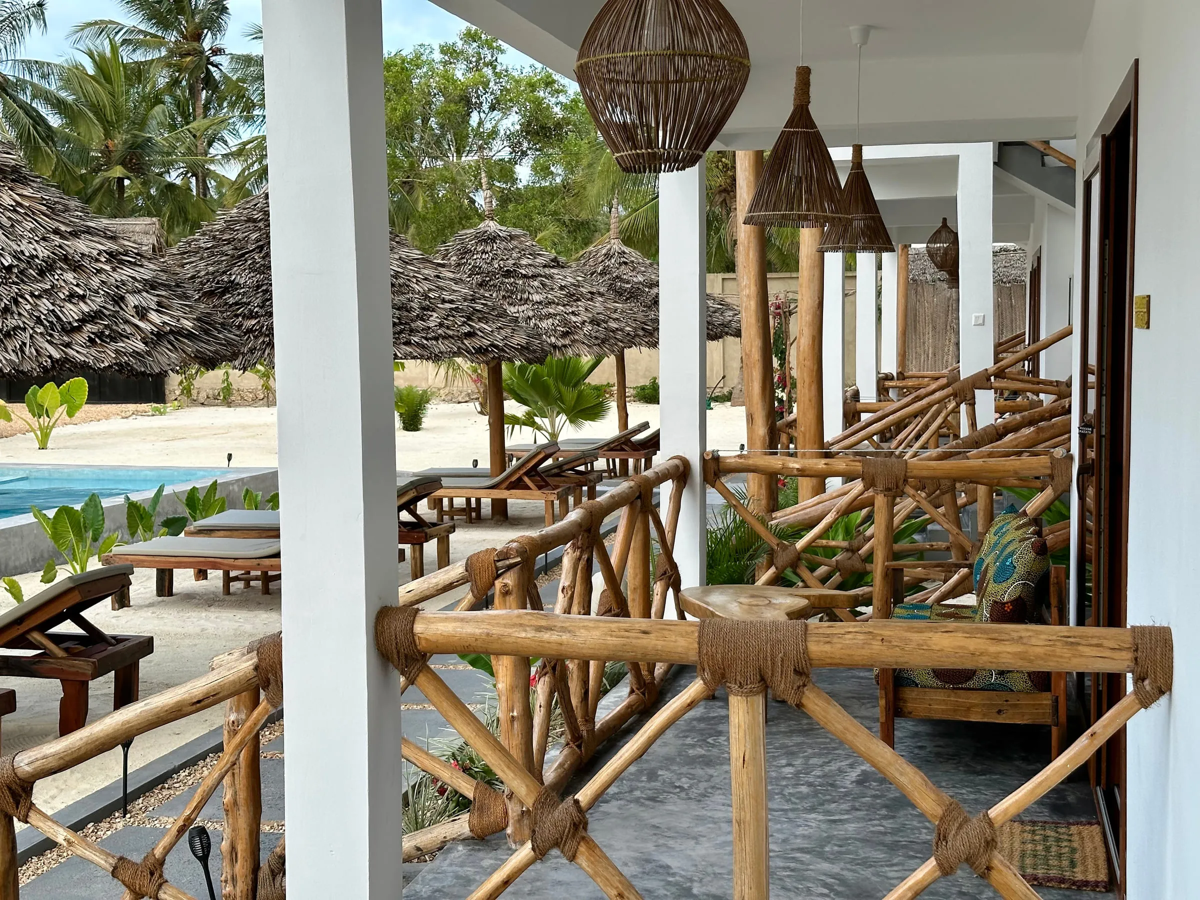 Close view of the hand-tied mangrove pole railing on the terrace with the pool behind