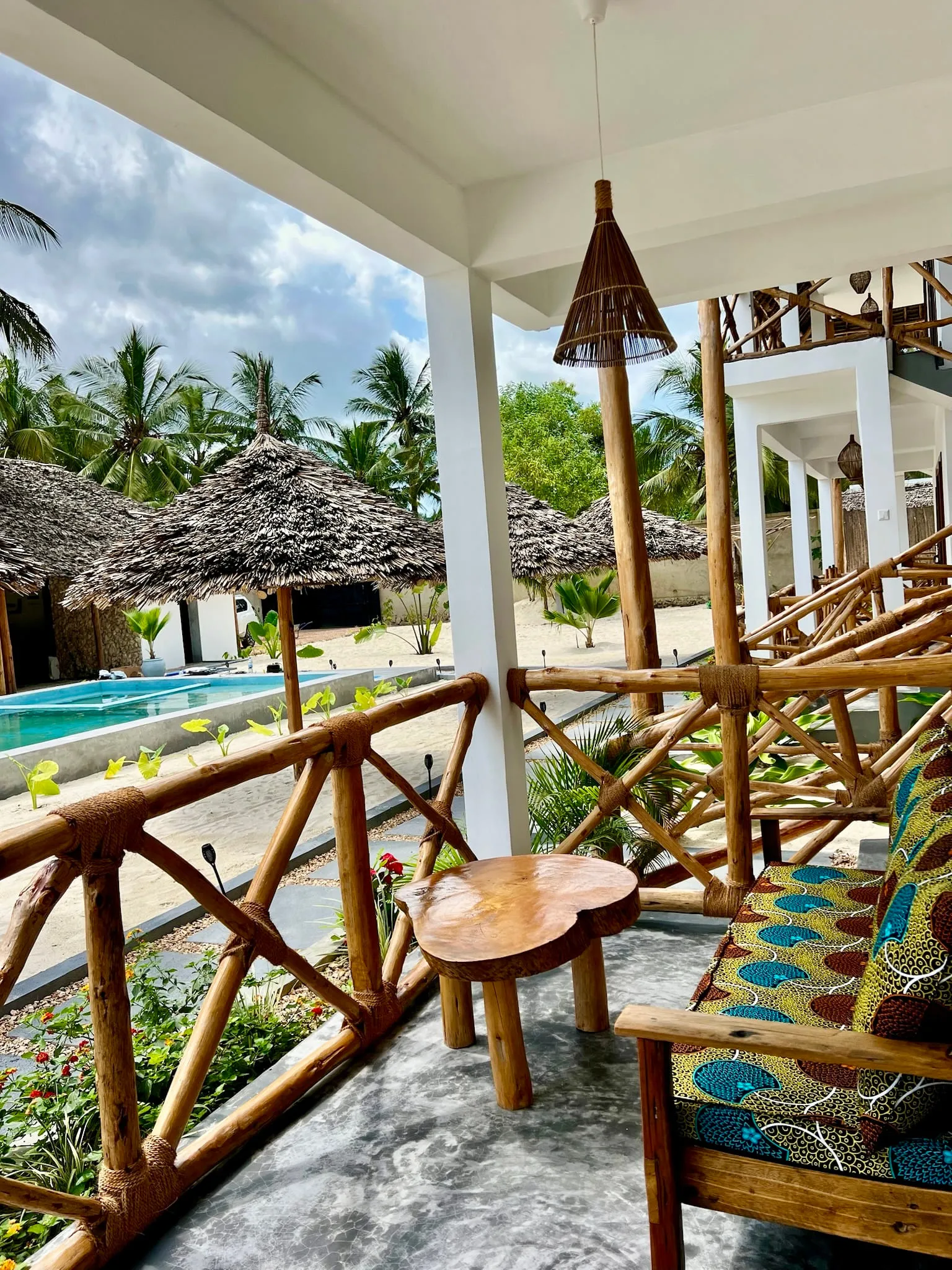 Looking out from a shaded first-floor terrace across the pool towards the sea